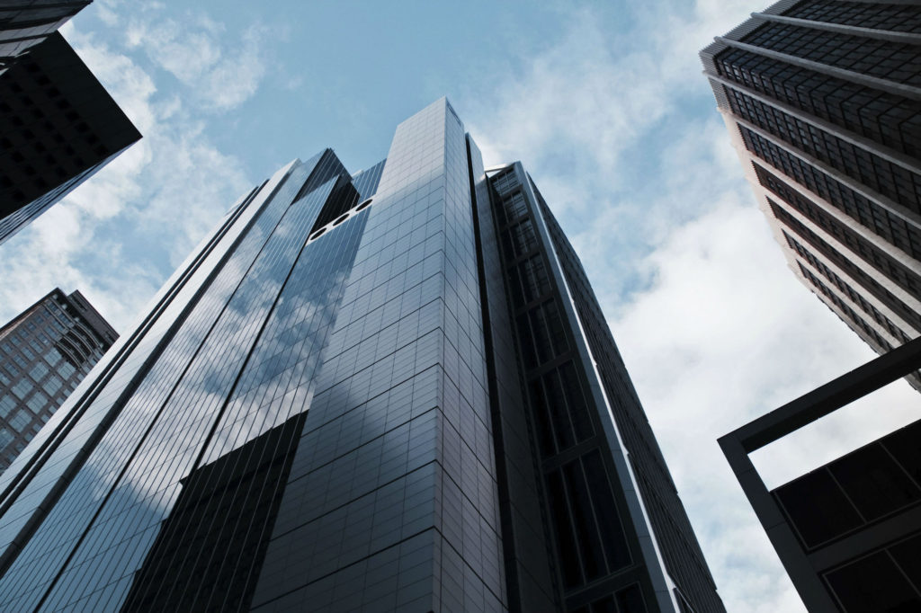 Glass office towers rising into a blue sky