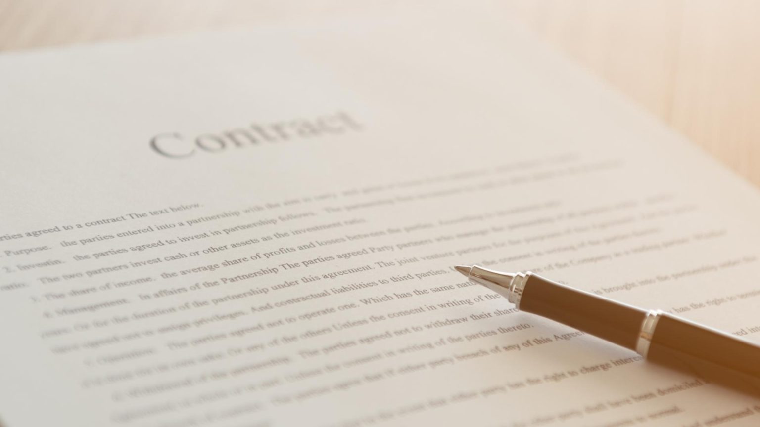 A pen resting on a printed contract ready for signature